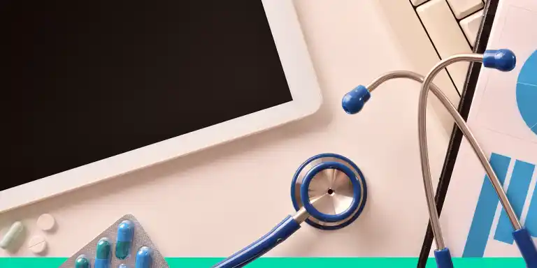 Dispositivos relacionados à IoT na medicina, incluindo tablet, estetoscópio, medicamentos e gráficos sobre mesa de trabalho