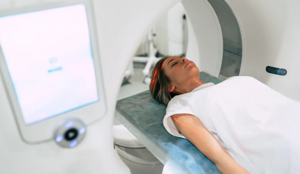 Paciente deitado em aparelho durante ressonância magnética, procedimento de diagnóstico por imagem em ambiente hospitalar.