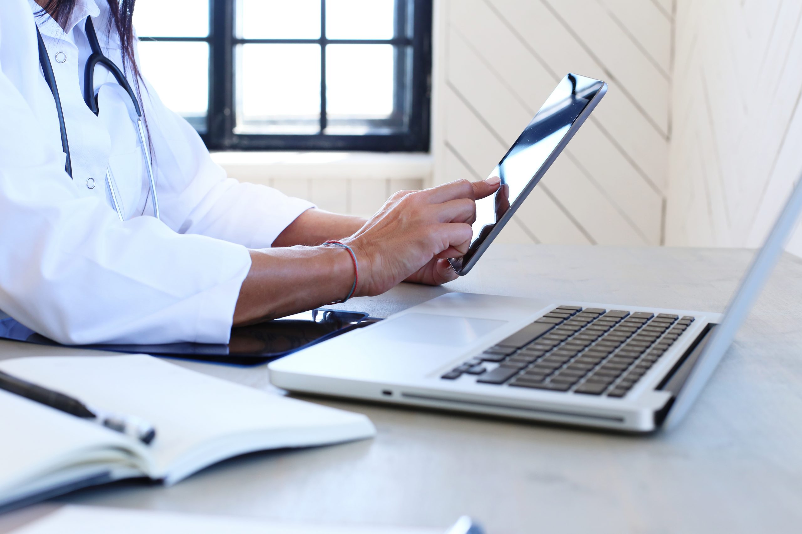 Médica usa tablet para trabalhar.