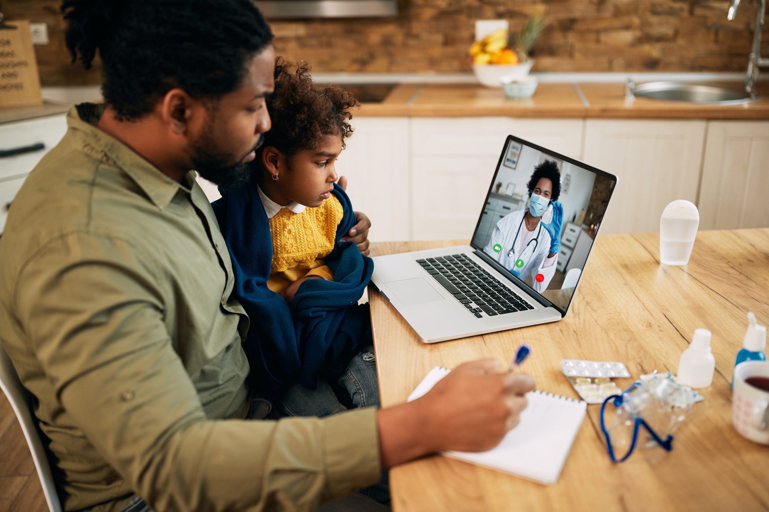 pai e filha são atendidos pela médica através da teleconsulta.