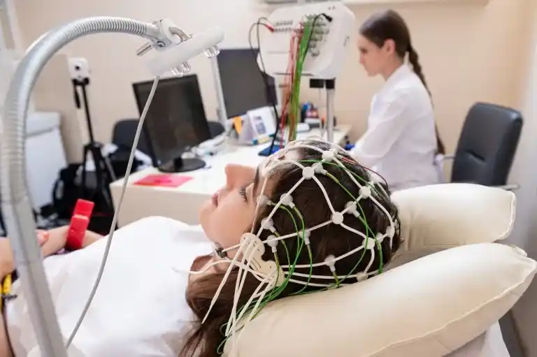 Paciente deitada realizando exame com aparelho de EEG