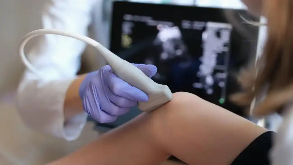 Exame Doppler sendo realizado na perna para análise da circulação