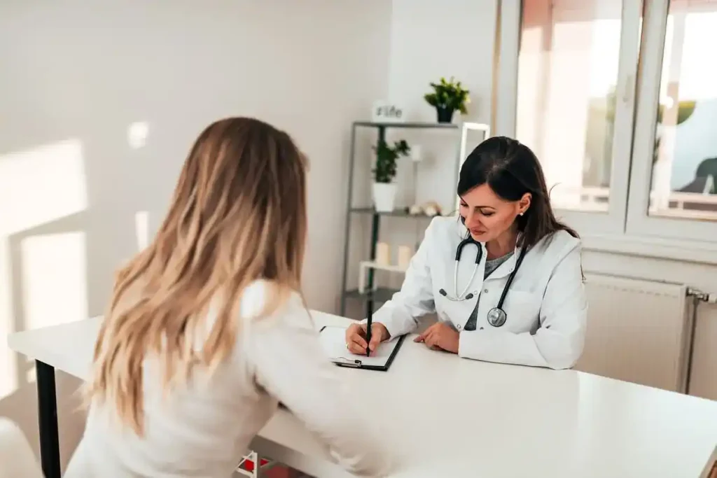 Médica em consulta com uma paciente, representando a realização de exames admissionais