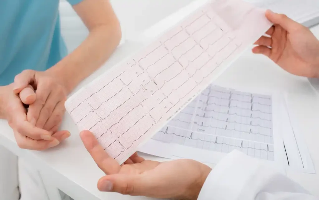 Profissional mostrando ECG a paciente, destacando o ritmo sinusal e interpretação dos sinais cardíacos