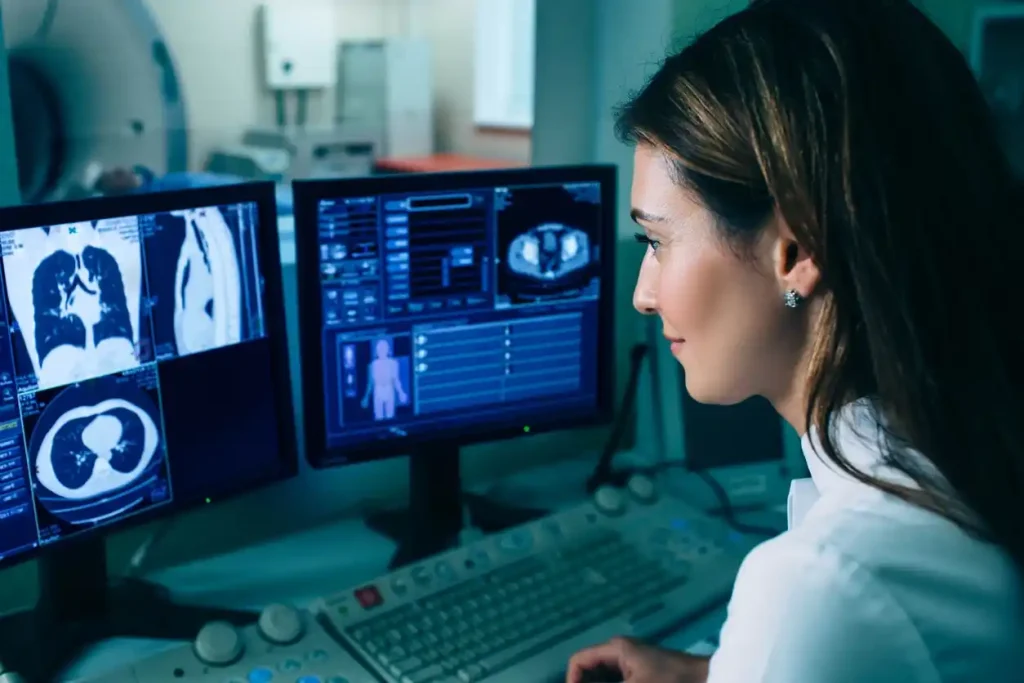 Profissional de saúde analisando imagens de tomografia do pulmão em monitores de computador
