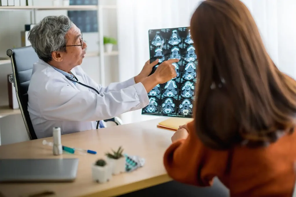 Médico analisando exames de imagem cerebral com paciente durante avaliação neurológica utilizando a escala NIHSS